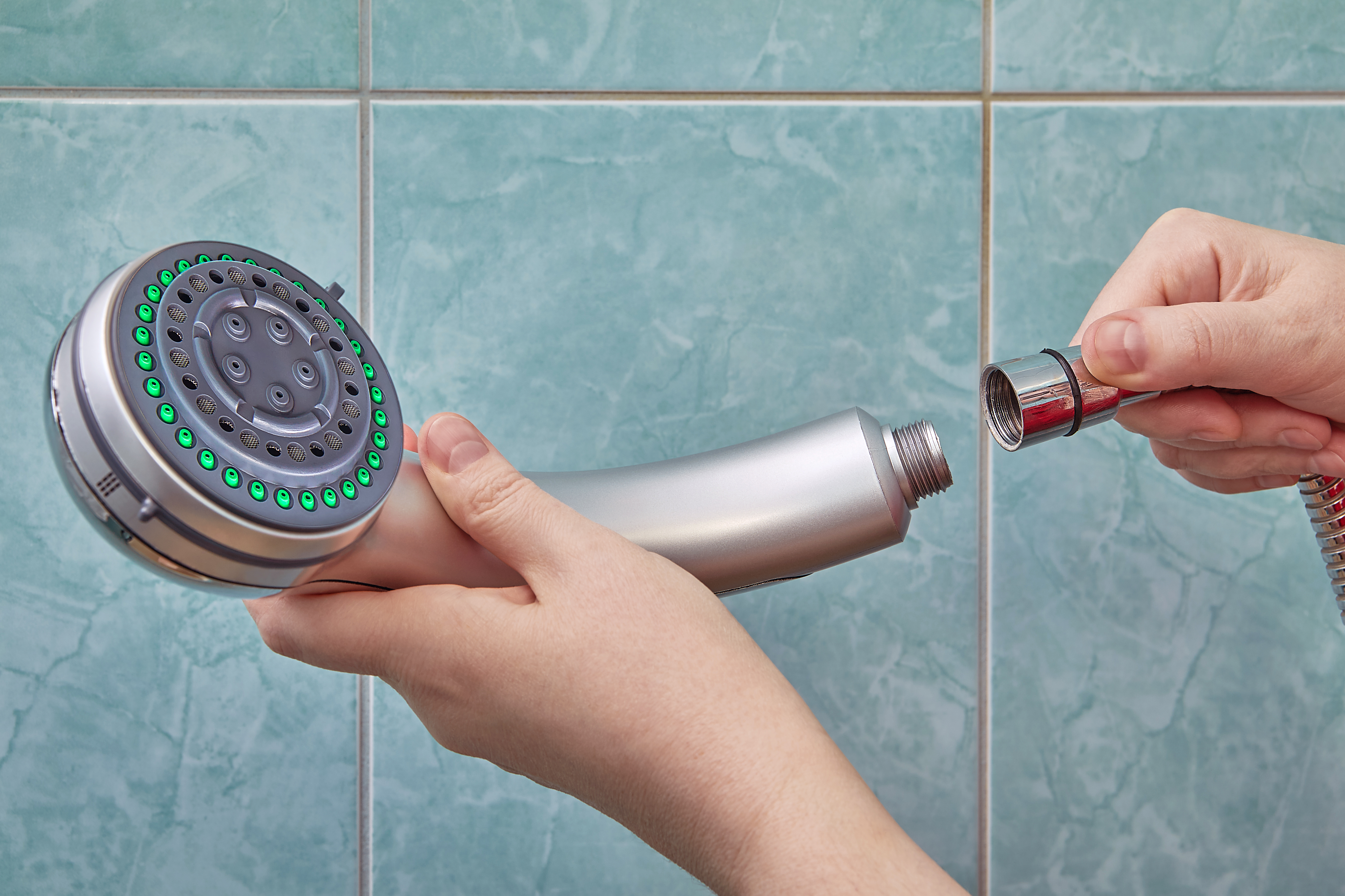 Person connecting showerhead to pipe