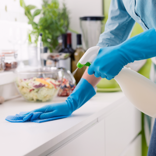 a person cleaning a surface using a disinfectant spray
