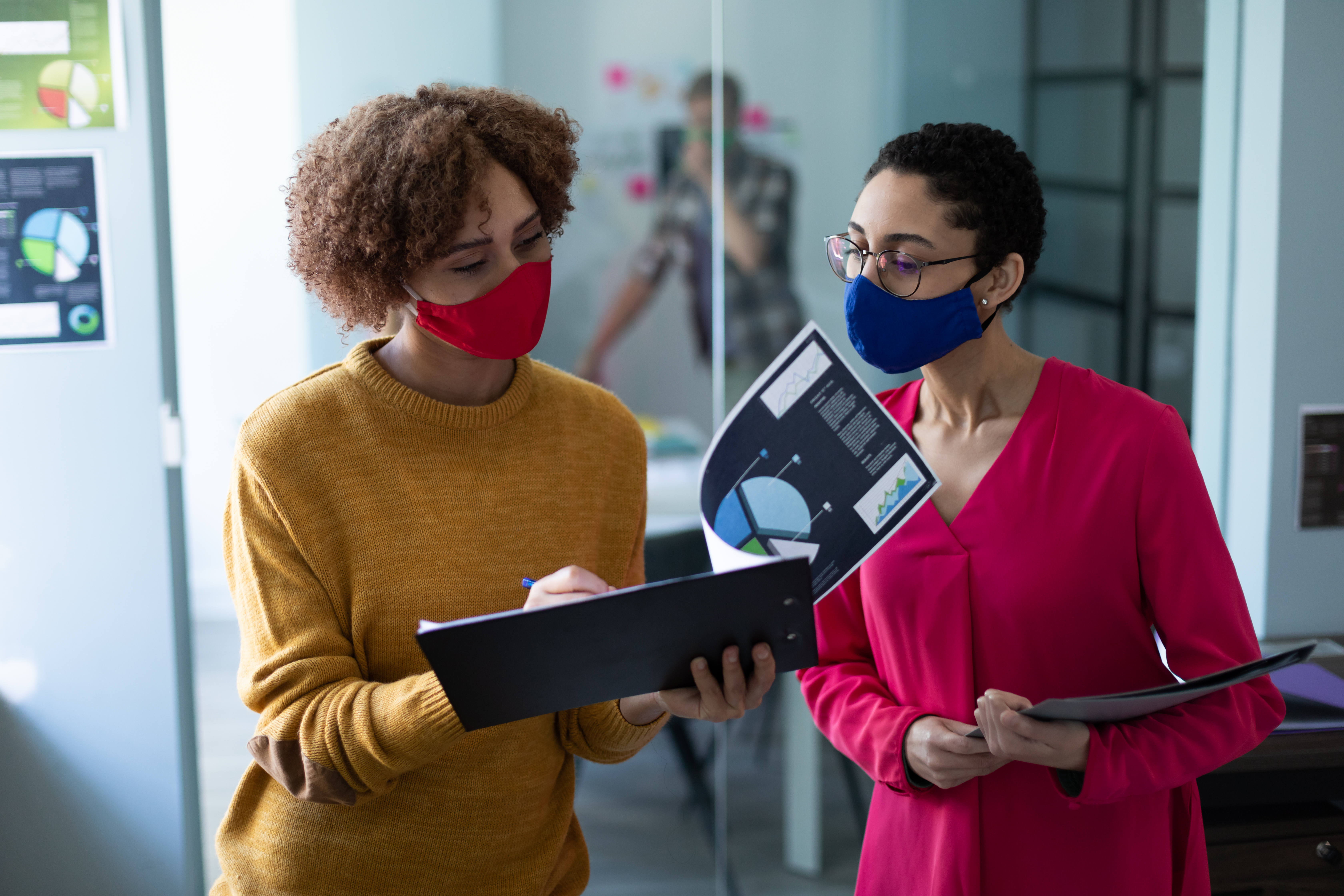 two women discussing while looking at file
