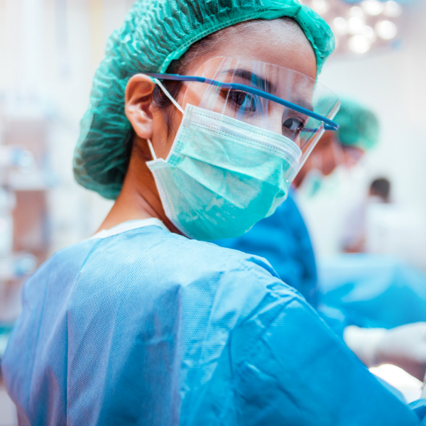 امرأة ترتدي بدلة واقية وقناعًا في المستشفى