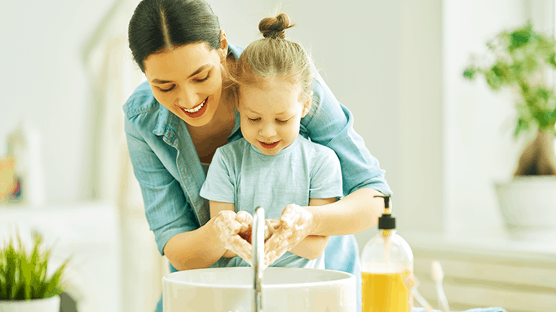 Mother and child washing hand together, helping to kill germs.